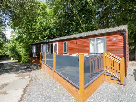 An outdoor view of a cabin with a deck at Feather Hill Lodge White Cross Bay near Troutbeck Bridge