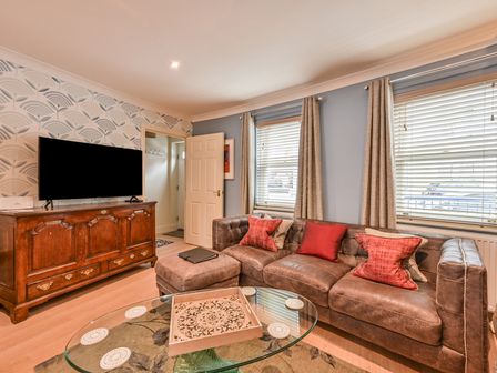 A living room with a sofa and television at Lisburne Place in Torquay