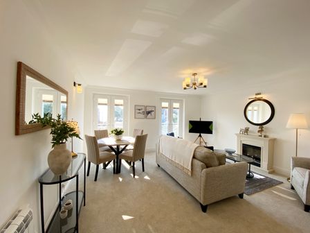 A living room with a sofa and a dining table at The Degas Sea View Suite in Torquay