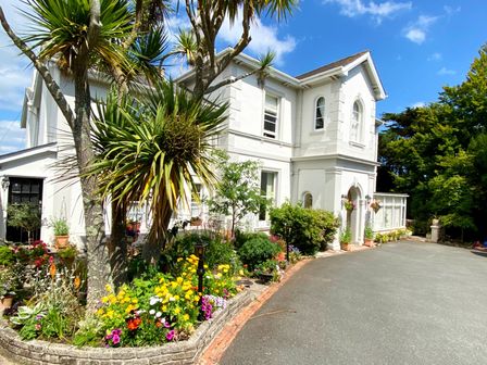 A house with a garden and flowers at Muntham Deluxe Apartment 2 in Torquay