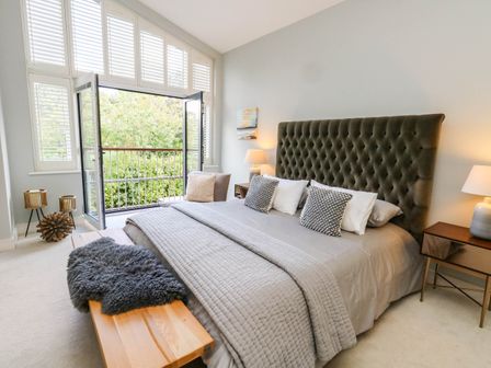 A bedroom with a bed and balcony view at Harbour Heights in Weymouth