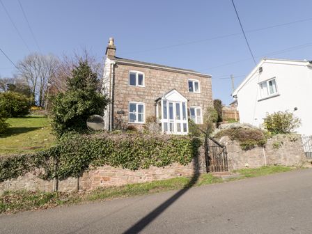 A stone house with ivy on the wall and a small porch next to a white house at Gordons View Pleasant Stile near Gloucester