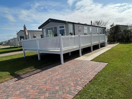a holiday home with a deck surrounded by grass at Skipsea Sands Holiday Park - Holiday Accommodation 10304 in Driffield