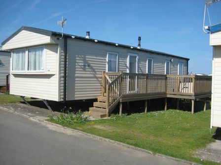a mobile home with a wooden deck and steps at Beachside Holiday Park - Holiday Accommodation 10605 in Brean