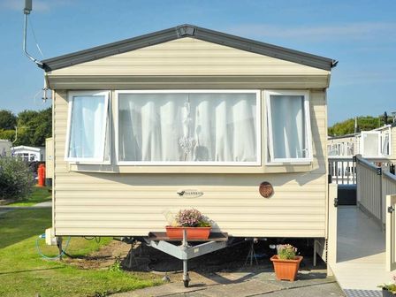 a static caravan with large windows and plants at Cala Gran Holiday Park - Holiday Accommodation 10830 in Fleetwood