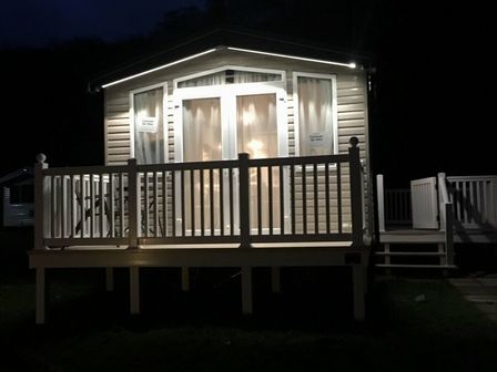 a holiday cabin with lights on at night at Kiln Park Holiday Park - Holiday Accommodation 1142 in Tenby