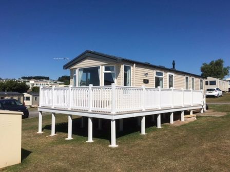 a holiday home on stilts with a white railing at Devon Cliffs Holiday Park - Holiday Accommodation 12076, Exmouth