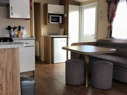 a kitchen area with a table and stools at Beachside Holiday Park - Holiday Accommodation 1208 in Brean
