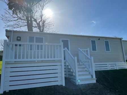 a mobile home with a white deck and stairs at Newquay Bay Resort - Holiday Accommodation 12239, Newquay