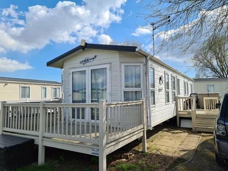 a mobile home with a deck and several windows at Orchards Holiday Village - Holiday Accommodation 12638, St Osyths
