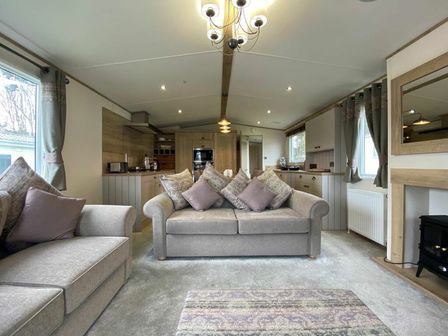 a living room with a sofa and kitchen area in Cayton Bay Caravan Park - Holiday Accommodation 12788, Cayton Bay