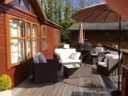 a patio area with seating and an umbrella at St Minver Holiday Park - Holiday Accommodation 13041 in Wadebridge