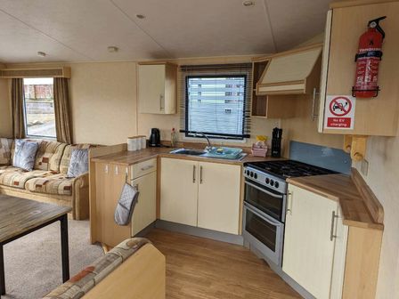a kitchen area with cabinets, stove, and sink at Aberystwyth Holiday Village - Holiday Accommodation 13184, Aberystwyth