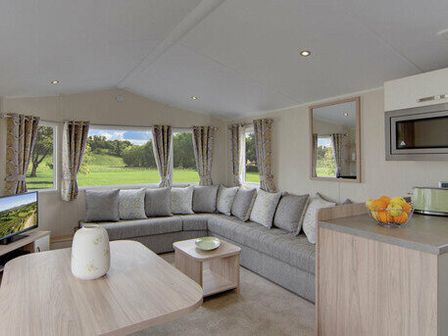 a living room with a grey sectional sofa and a coffee table at Waterside Bowleaze Cove Holiday Park - Holiday Accommodation 1326 in Weymouth