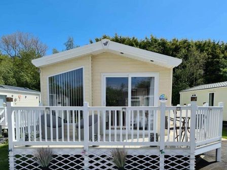 a holiday home with a front deck and large windows at Burnham-on-Sea Holiday Park - Holiday Accommodation 13315, Burnham-on-Sea