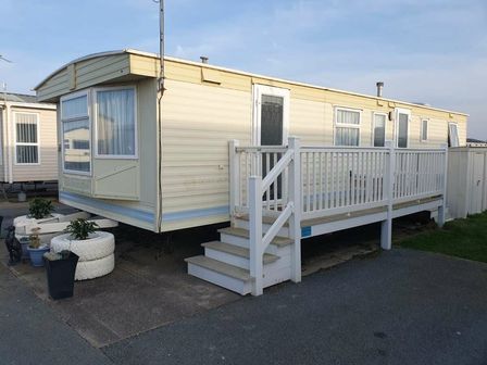 a static caravan with a wooden deck and steps at Golden Sands Kinmel Bay - Holiday Accommodation 13386 in Towyn