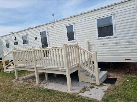 a mobile home with a front deck and steps at Presthaven Beach Resort - Holiday Accommodation 14316, Prestatyn