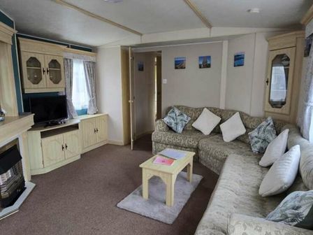 a living room with a sofa, TV unit, and coffee table at Clarach Bay Holiday Village - Holiday Accommodation 14820 Aberystwyth