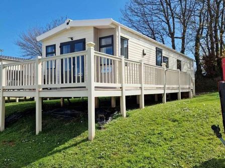 a holiday home on a grassy area with a wooden deck at Hoburne Devon Bay - Holiday Accommodation 14969 in Paignton