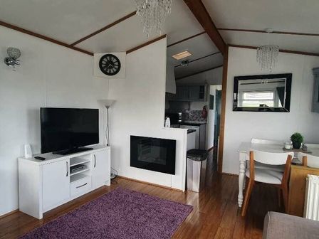 a living room with a TV, a lamp, a dining area, and a kitchen at Ocean Edge Leisure Park - Holiday Accommodation 15166, Morecambe