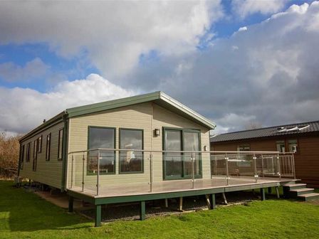 a holiday home with a deck and large windows at Hafan y Mor Haven - Holiday Accommodation 15414 in Pwllheli
