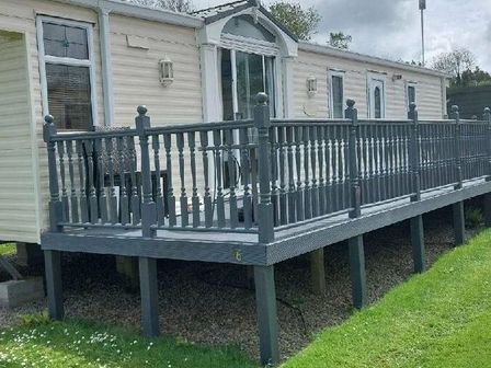 a mobile home with a wooden deck and railing at Little Bodieve - Holiday Accommodation 15475 Wadebridge