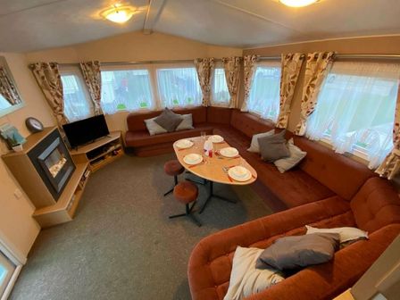 a seating area with a round table and couch at St Osyth Holiday Village - Holiday Accommodation 15756, Clacton-on-Sea