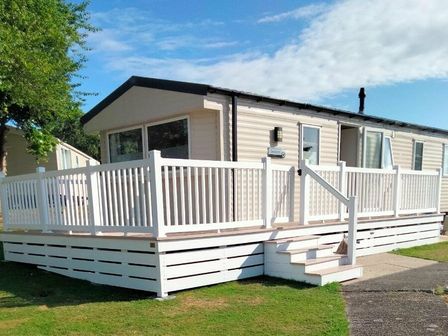 a holiday home with a white deck and steps at Hafan y Mor Haven - Holiday Accommodation 15817 Pwllheli