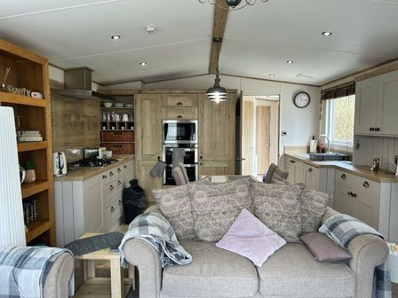 a kitchen and living area with a sofa and cabinets at Ocean Edge Leisure Park - Holiday Accommodation 15961 in Morecombe