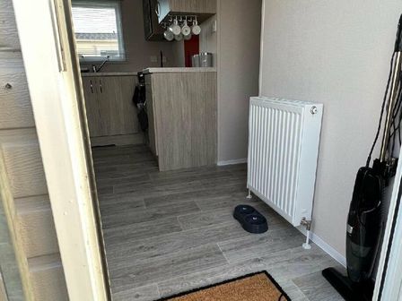 a hallway with a kitchen visible, a radiator, and a vacuum cleaner at Unity Holiday Resort - Holiday Accommodation 16371, Brean Sands