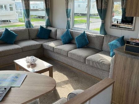 a living room with a large gray sectional sofa and blue cushions at Tattershall Lakes Country Park - Holiday Accommodation 16405, Lincoln