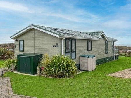 a green holiday home with gardens on the side at Hafan y Mor Haven - Holiday Accommodation 16778 Pwllheli