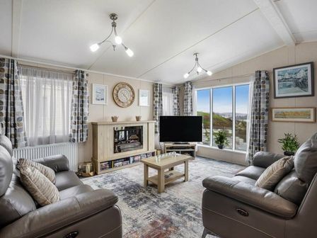 a living room with a fireplace, television, and seating at Waterside, Paignton - Holiday Accommodation 16866