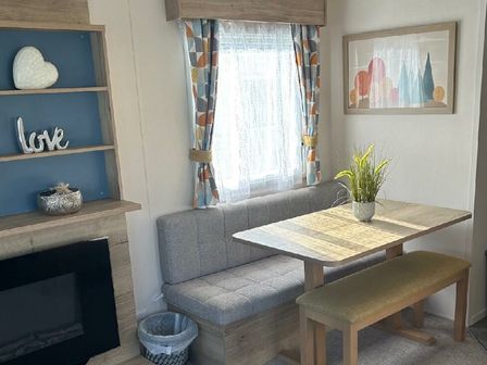 a dining area with a table and benches at Blue Dolphin Holiday Park - Holiday Accommodation 17282, Filey