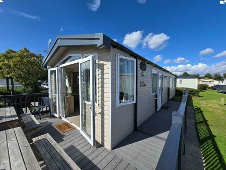 a holiday accommodation with a wooden deck and open doors at Cleethorpes Beach Holiday Park - Holiday Accommodation 17392, Cleethorpes