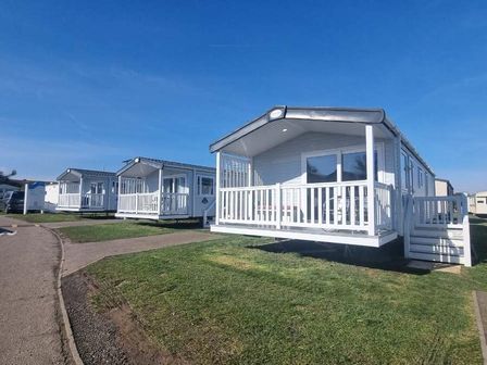 a row of holiday homes with white exteriors and porches at Caister Holiday Park - Holiday Accommodation 17607 Caister-on-Sea