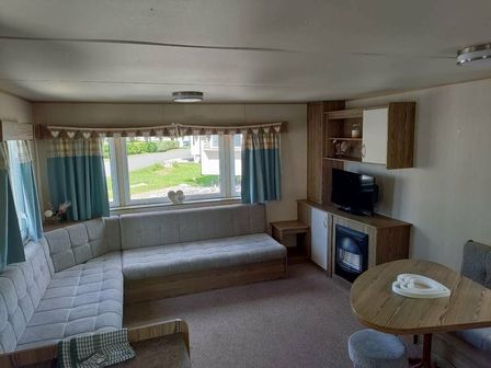 a living room with a sofa, a television, and a dining table at Marton Mere Holiday Village - Holiday Accommodation 17751, Blackpool