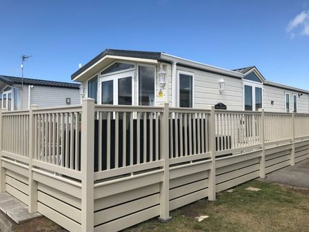 a holiday caravan with a wooden deck at Golden Sands Kinmel Bay - Holiday Accommodation 17988 in Towyn