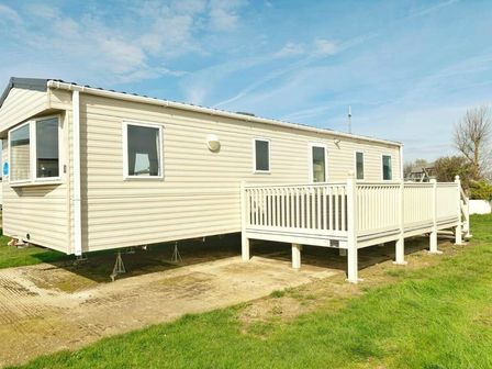 a mobile home with a wooden deck and grass surrounding at Heacham Beach Parkdean Resorts - Holiday Accommodation 18026, Heacham