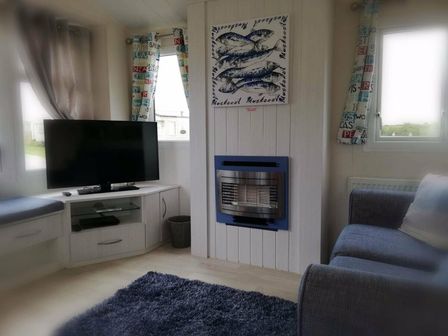 a living room with a television, seating area, and a fireplace at Seven Bays Park (Maribou) - Holiday Accommodation 18106, St Merryn