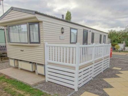a caravan with a white wooden deck at Avon Caravan Park - Holiday Accommodation 18132 Stratford Upon Avon