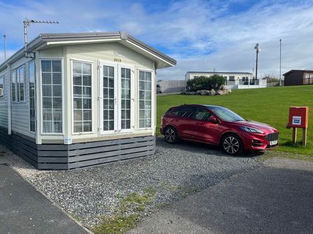 a holiday home with a car parked beside it at Ocean Edge Leisure Park - Holiday Accommodation 1822 Heysham