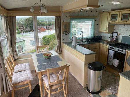 a kitchen dining area with a table and chairs at Aberystwyth Holiday Village - Holiday Accommodation 18404, Aberystwyth