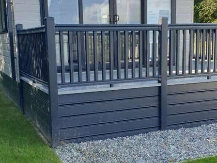 a balcony with a black railing and stone base at White Acres Holiday Park - Holiday Accommodation 18583 Newquay