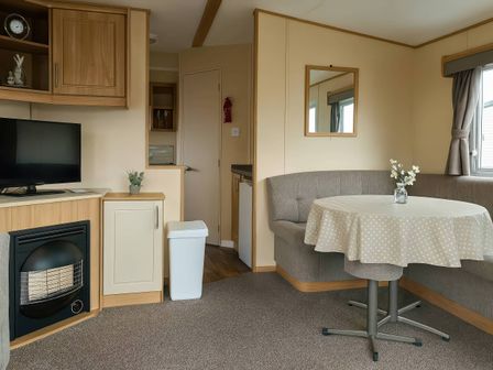 A living room with a television and coffee table at Golden Gate Holiday Centre - Holiday Accommodation 19059 Towyn