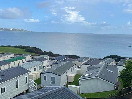 a view of holiday homes with the sea in the background at Waterside, Paignton - Holiday Accommodation 19143, Paignton