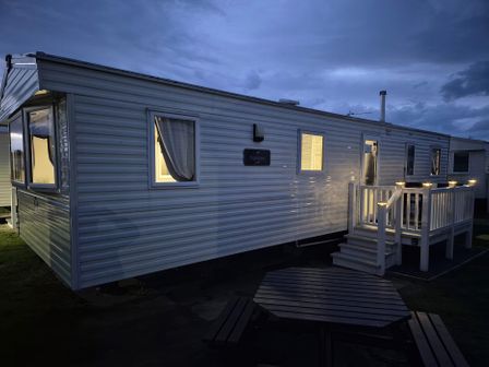 A caravan with steps and outdoor furniture at Presthaven Beach Resort - Holiday Accommodation 19166, Prestatyn