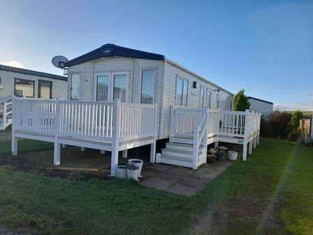 a mobile home with a deck and stairs at Durdle Door Holiday Park - Holiday Accommodation 19199 Wareham