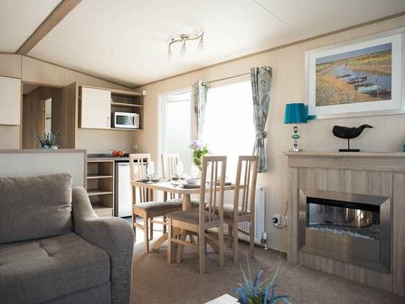 a dining area with a table and chairs in a lounge at Rockley Park - Holiday Accommodation 19384, Poole