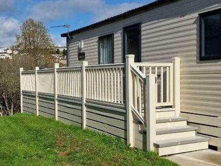 a deck with a railing and steps leading to a mobile home at Hoburne Devon Bay - Holiday Accommodation 19665 in Paignton